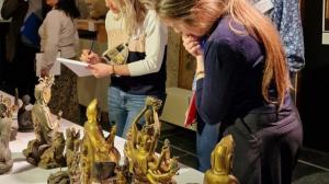 Visiteurs devant des statuettes de Bouddha