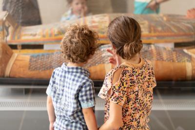 Deux enfants devant une vitrine avec un sarcophage